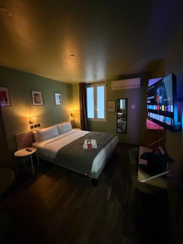 a bedroom with a bed and a flat screen tv at Hotel de Berne in Nice