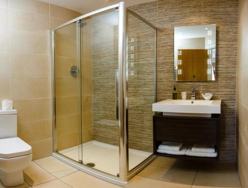 uma casa de banho com um chuveiro e um lavatório. em Adamson Hotel em Dunfermline