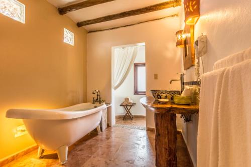 y baño con bañera y lavamanos. en Ser Casasandra Boutique Hotel en Holbox Island