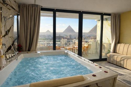 een jacuzzi in een kamer met uitzicht op de piramides bij Zoom Pyramids View inn in Caïro