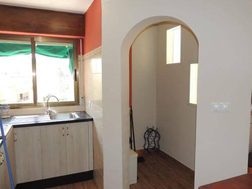 a kitchen with an archway and a sink and a window at Apartamento Les Fonts in Polop