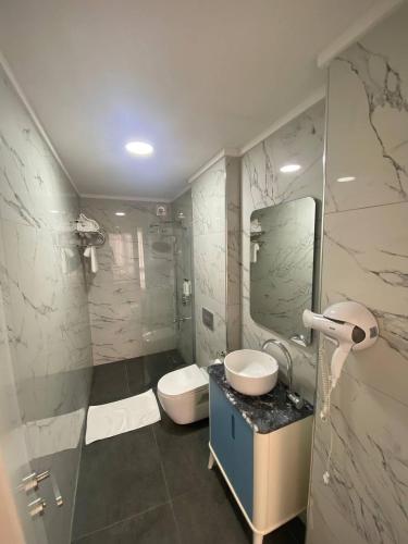 a bathroom with a sink and a toilet and a mirror at No25 Hotels in Çorlu