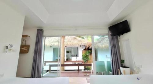 een slaapkamer met een bed en uitzicht op een patio bij Sawasdee Coco Resort in Ko Samed