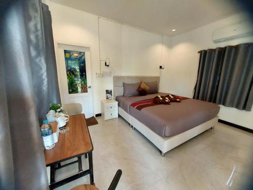 een slaapkamer met een bed en een tafel erin bij Star Garden Home in Ko Jum