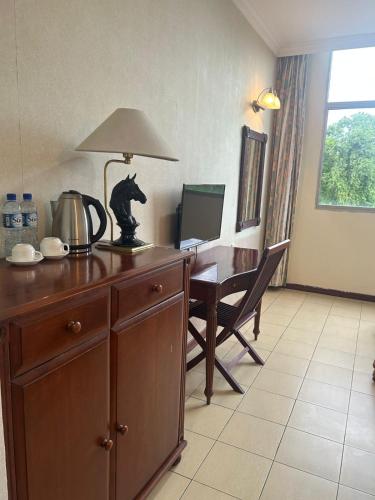 a room with a desk with a lamp and a computer at Golden Village Hotel in Kampong Selangan