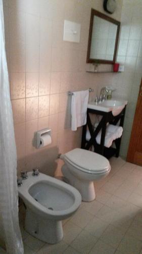 y baño con aseo y lavamanos. en Cabaña La Cumeleña, en Villa La Angostura