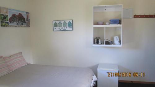 a bedroom with a bed and a medicine cabinet at Catlins Newhaven Holiday Park in Owaka