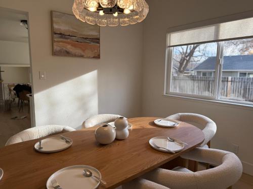 ein Esstisch aus Holz mit Stühlen und einem Kronleuchter in der Unterkunft New! Modern 4BR max 12 ppl, 5 mins to everything! in Reno