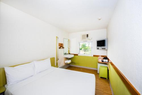 a hotel room with a white bed and a window at ibis Budget Wentworthville in Wentworthville