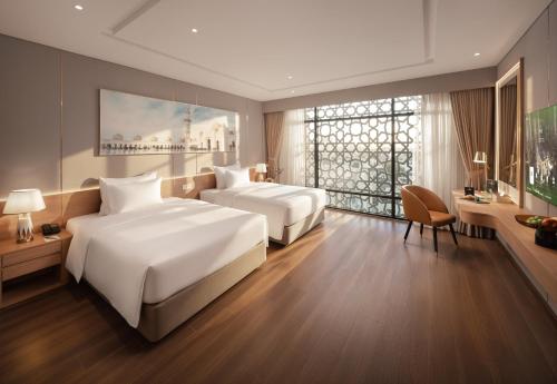 a hotel room with two beds and a large window at Anyla Grand Hotels in Thanh Hóa