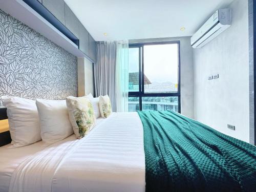 a bedroom with a large bed with a large window at Modern Urban Living Kamala in Kamala Beach
