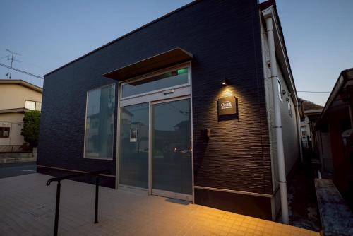a black building with a large glass door at PREMIUM O2stay citrus onomichi in Onomichi