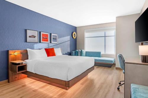 a bedroom with a bed and a blue wall at Cambria Hotel Northlake Conference Center - Roanoke in Northlake