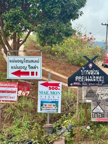 a bunch of signs on the side of a road at Maemon villa แม่มอญ วิลล่า in Ban Ri So