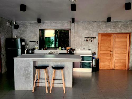 eine Küche mit Theke und zwei Barhockern in der Unterkunft Eskobar Villa Exclusive in Baan Tai