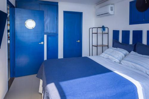 a blue bedroom with a bed and blue doors at Balcony to the Horizon in Cartagena de Indias