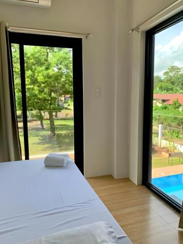 a bedroom with a bed and a large window at Lindelle Place Palawan in Puerto Princesa City