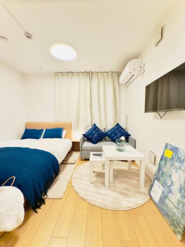a bedroom with a bed and a couch and a tv at Kyo-wa Hotel Kinshicho in Tokyo
