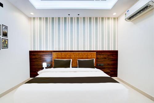 ein Schlafzimmer mit einem großen Bett mit einem hölzernen Kopfteil in der Unterkunft Townhouse Oak Ram Lala Mandir Kanpur Formerly Hotel Sun Rise in Kaliānpur