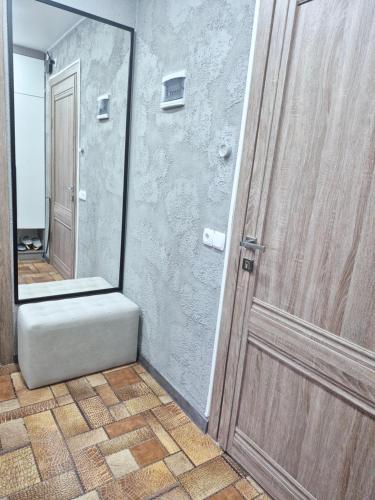 a bathroom with a wooden door and a mirror at Отдых перед и до вылета самолёта in Astana