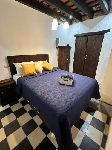 a bedroom with a blue bed with yellow pillows at Refugio de las Estrellas in Antigua Guatemala
