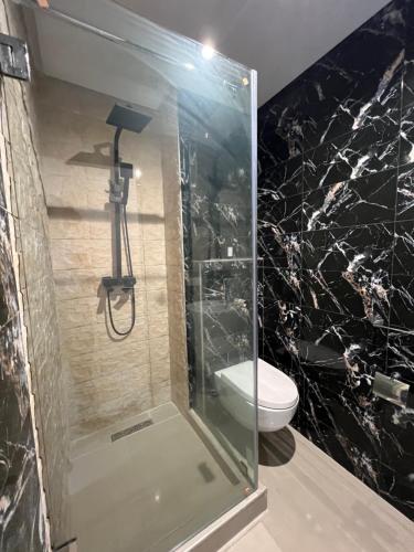 a bathroom with a glass shower with a toilet at Appartement à Bahia Golf Beach Spacieux de 126 m in Bouznika