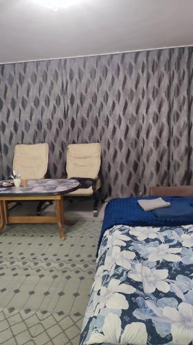 een slaapkamer met twee stoelen en een bed en een tafel bij WloterStyl 1 in Warschau
