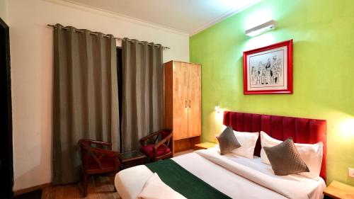 a hotel room with a bed with green walls at Hotel Rustam Residency sec-39 in Gurgaon