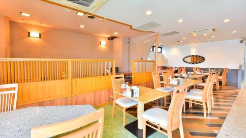 a dining room with wooden tables and chairs at First Inn Haiki in Sasebo