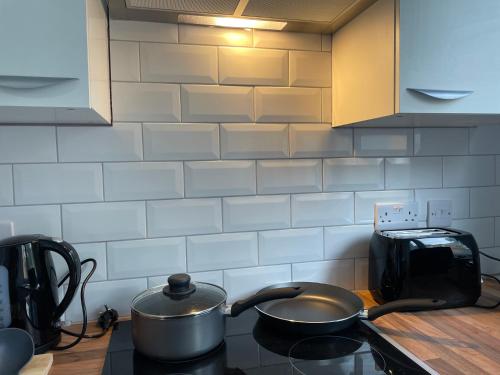 a pot sitting on top of a stove in a kitchen at Skyway Suites Luton in Luton