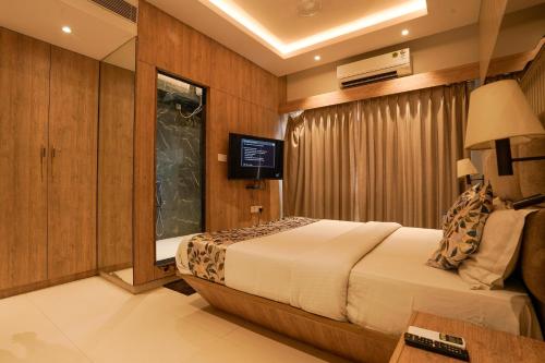 ein Hotelzimmer mit Bett und Fernseher in der Unterkunft The Food Villa in Mumbai