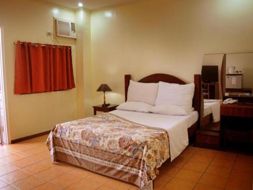 een slaapkamer met een bed en een rood gordijn bij Walk Around Hotel in Angeles