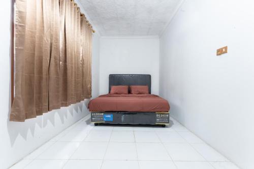 a bed sitting on top of a white floor in a room at Sutedjo Telaga bedakah in Bedakah