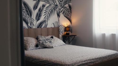 a bedroom with a bed with a tropical wallpaper at La Kaz Eden * * * * in Les Cocos