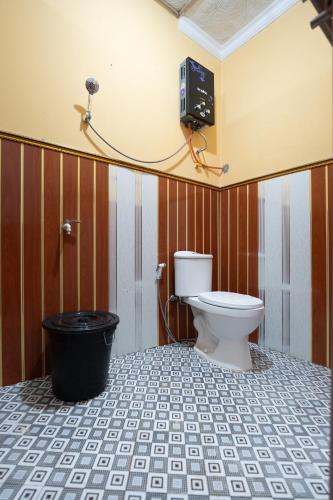 a bathroom with a toilet and a television on the wall at Sutedjo Telaga bedakah in Bedakah