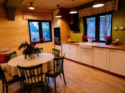 een keuken met een tafel en stoelen in een kamer bij Karmuszka Leśna Weranda in Łukta