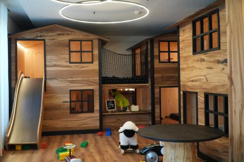 een kamer met houten muren, een tafel en een hond bij Ravelli Sporting in Mezzana