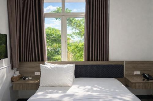 ein Bett in einem Zimmer mit einem großen Fenster in der Unterkunft Minh Hà Hotel Hồ Chí Minh in Ho-Chi-Minh-Stadt