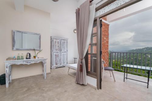a living room with a desk and a balcony at Earthbound Residence in Kandy