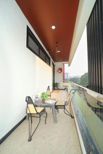 a balcony with two chairs and a table on a building at Taj Holiday Villa in Agra