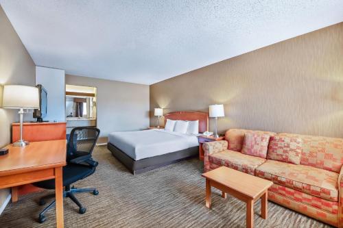 een hotelkamer met een bed, een bank en een bureau bij Econo Lodge Inn & Suites in North Vancouver