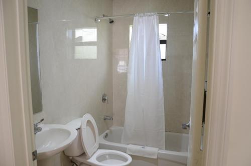 y baño con aseo, lavabo y ducha. en Carl's El Padre Motel, en Miami