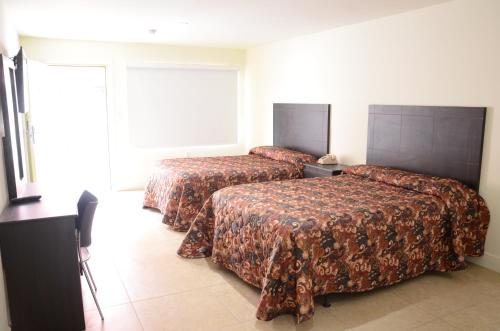 Cette chambre comprend 2 lits et une fenêtre. dans l'établissement Carl's El Padre Motel, à Miami