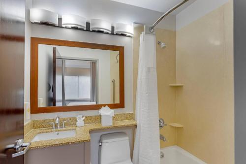 ein Badezimmer mit Waschbecken, Toilette und Spiegel in der Unterkunft Comfort Inn in Staten Island