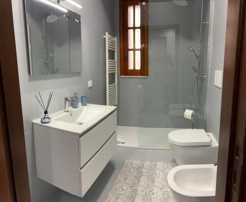 a white bathroom with a sink and a toilet at Casa Vacanze Villa Chiara in San Vito
