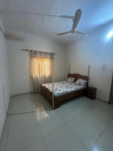 een slaapkamer met een bed en een plafondventilator bij La maison de Kalabancoura in Bamako