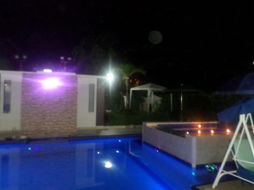 a swimming pool in front of a house at night at Casa Quinta Santana in Melgar