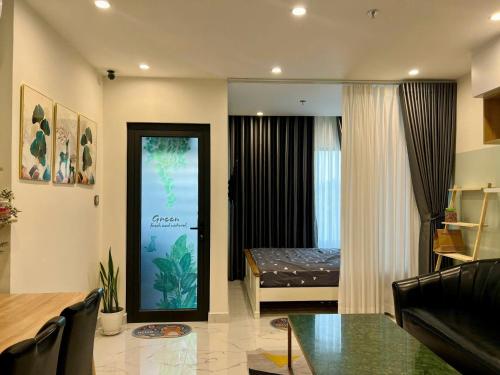 a living room with a room with a bed and a table at Alex Vinhomes Grand in Gò Công