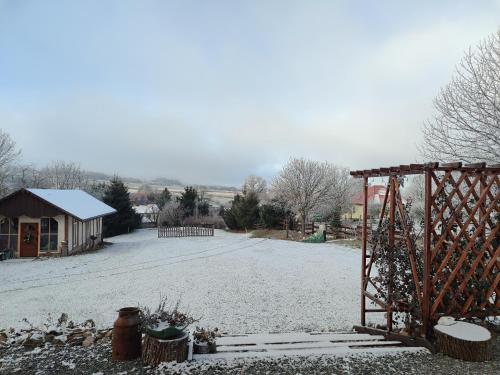 a snow covered yard with a gate and a building at Pod Aniołem 2 in Dobków
