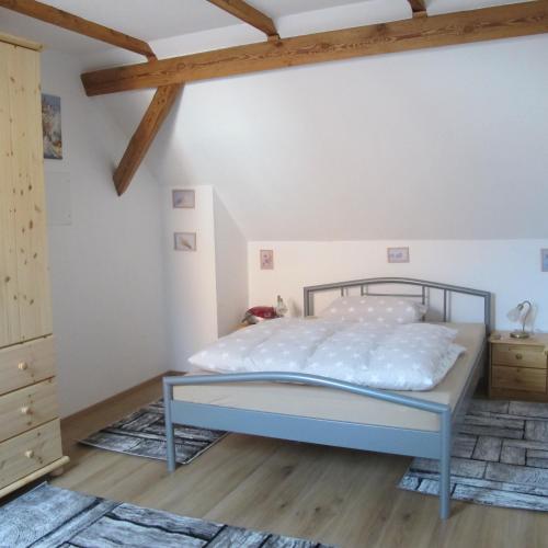 a bedroom with a bed and a wooden floor at Ferienwohnungen Pustane in Neu Zauche